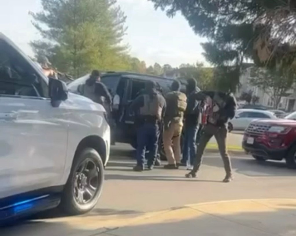 An April 20 Post from Cville ICE Watch shows alleged agents in tactical gear surrounding a&nbsp;vehicle